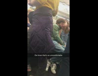 Couple makes out on subway, green jacket, denim overalls