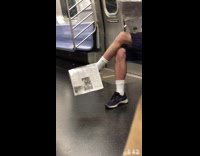 Old guy sits with newspaper on his foot 