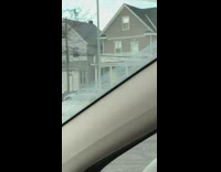Wetsuit guy carries blue surfboard snow car