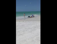 Two ladies dressed as mermaids lay on beach for video 