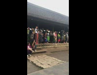 Long Line of People Wait for Photo with Temple 