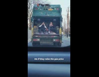 Two guys hitch ride on garbage truck