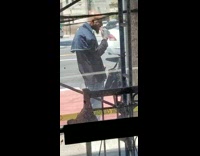 Bald guy brushes teeth on sidewalk 