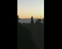 Black boots girl walks across grass beach 