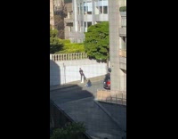 Black pants guy sits concrete cylinder sidewalk