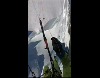 Guy flying over mountain on parachute spins 