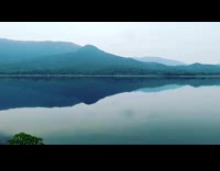 View of the lake with mountains around and a thick fog