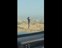 Man with a long hair with DSLR camera took a selfie