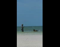 Woman wet hair flip beach cameraman laughs