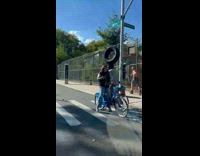 Man rides bike balances tire on head