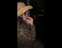 Man cowboy hat plays harmonic on balcony