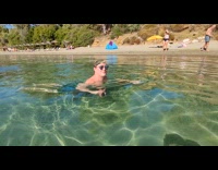Man at beach approached by cormorant bird 