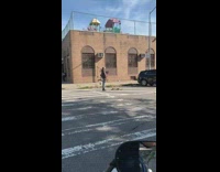 Guy black boots plays bagpipes street road