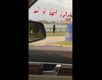Girl takes videos next to river Canadian flags