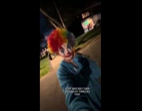 Woman wearing scary clown costume walking on street