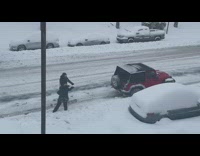 Red car pulls two guys on snowboards 