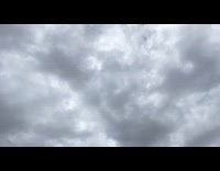 Blue kite flail on sky hits camera