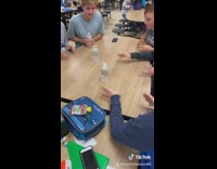 Guys boys pushing bottles across table in pattern