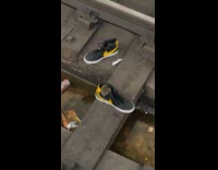 Rat goes over shoes on subway tracks
