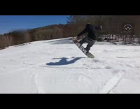 Snowboarder rides down slope, spins back and forth, and scorpions into snow