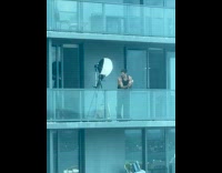 Man tank top photoshoot outside building balcony