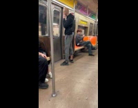 Man on subway talking to ladle like a phone