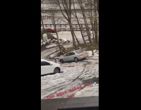 Car slides down steep frozen road 