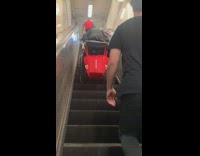 Guy with wheelchair walks up broken escalator 