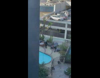 Man in black top raps near the pool