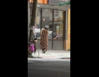 Guy wears coat in the heat 