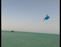 Guy does a flip in the air with parasail 