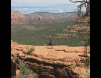 Woman in black outfit attempts to do a headstand yoga