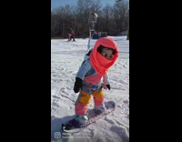 Small kid snowboarding in outfit