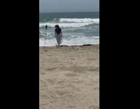Woman beach pants spins beach waves tripod
