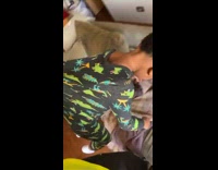 Dad picks up asleep son on sofa by pajamas