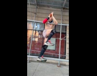 Man shirtless exercises with the scaffolding bar