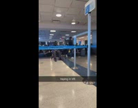 Guy smokes his vape device wearing VR headset at airport