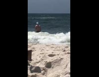 Wave hits woman falls down beach