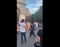 Man dances tire on head near monks