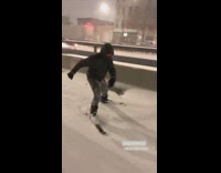 Guy skis down sidewalk covered in snow 