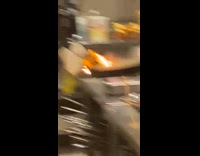 Chef with burning towel moves pan with fire 
