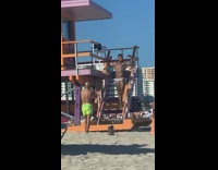 Man brief flex biceps lifeguard post beach