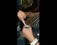 Girl opens green beer bottle with lip gloss