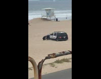 Police car gets stuck in sand at beach 