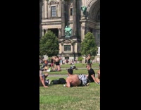 Shirtless guy black skirt white suspenders grass