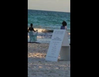 Woman in cyan dress walks at the beach