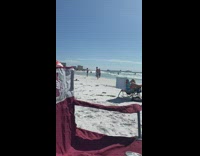 Guy holds legs pink bikini girl handstand