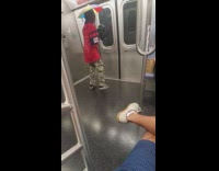 Guy rainbow umbrella hat red shirt subway 