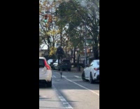 Man riding tall bike on street