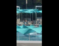 Girl denim shorts at pool blue umbrellas